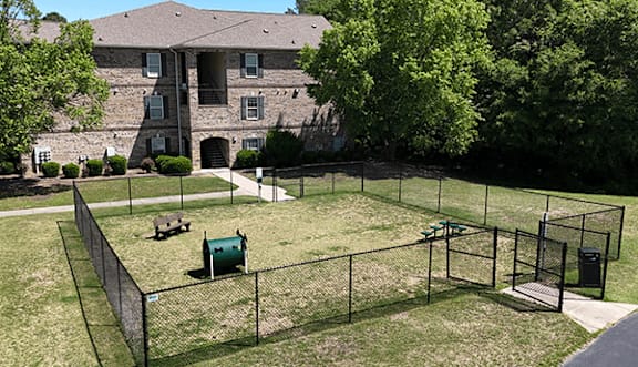 A large building with a fenced in yard in front.