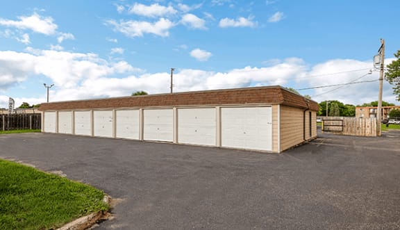 a large garage with a brick roof and white garage doors