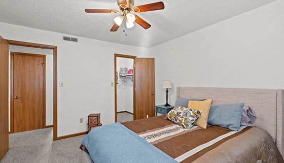 a bedroom with a large bed and a ceiling fan