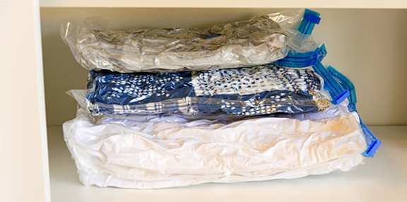 A white cabinet drawer is full of plastic-wrapped items.