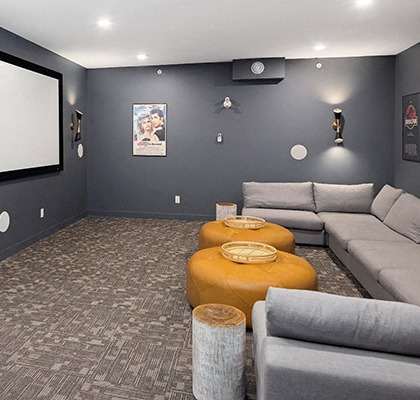 a living room with couches and a screen on the wall