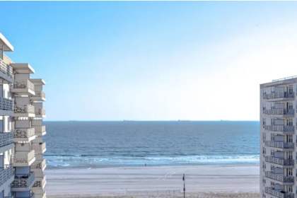 A beachfront building overlooks the ocean.