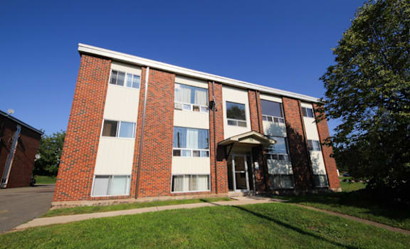 A red brick building with a white trim and a white door.