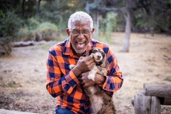 an older man holding his dog in a park at Loma Linda Springs, Loma Linda, CA, 92354