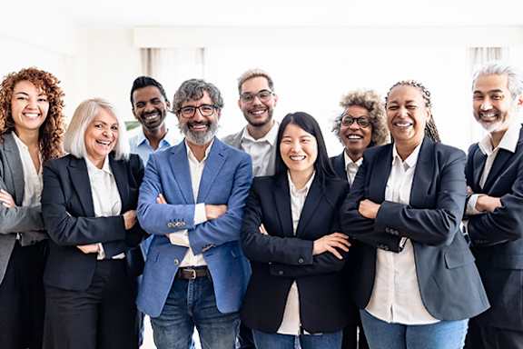 A group of professionals in business attire are standing together in a team.