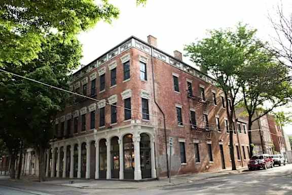 A building with a red brick facade and a balcony with a window.