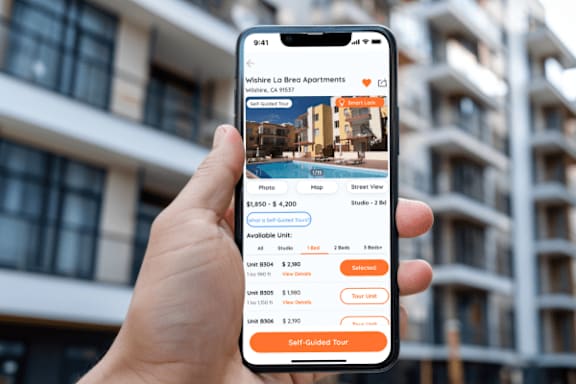 A person is holding a phone showing a self-guided tour option for Wishere Loire Apartments.