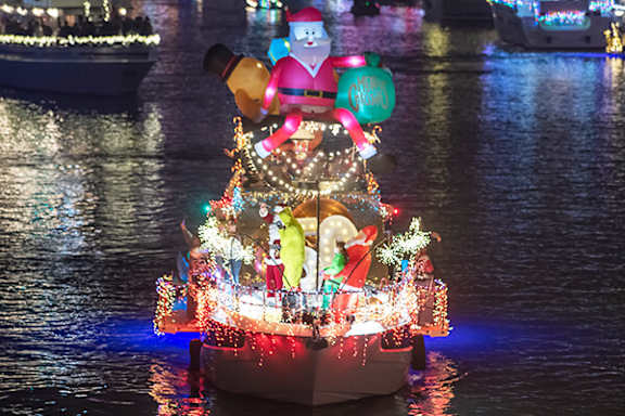 A boat with a Christmas theme is on a body of water.