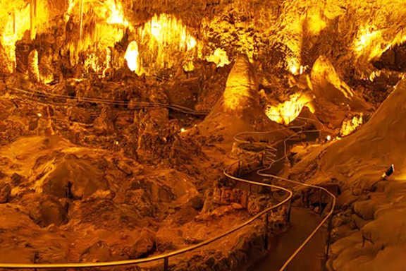 A winding road through a cave with a yellowish tint.