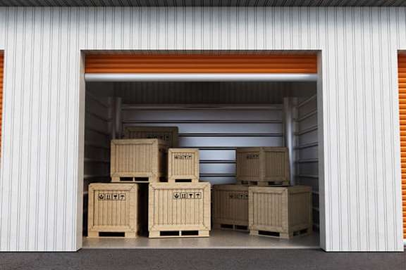 A storage facility with boxes labeled "SALT" and "SAND" in the doorway.