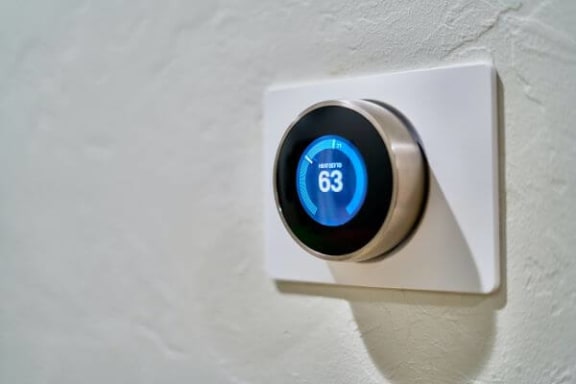 a white thermostat on a white wall