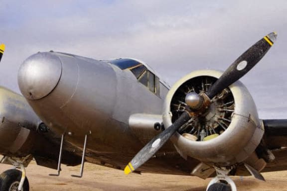 an old airplane is parked in the sand