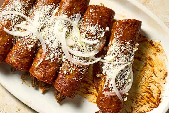 A plate of food with onions and powdered sugar on top.