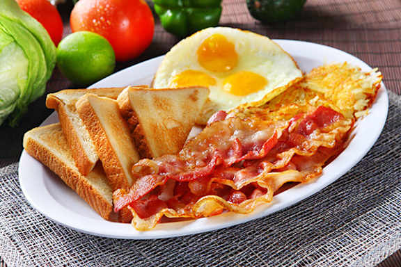 A plate of breakfast with eggs, bacon, and toast.