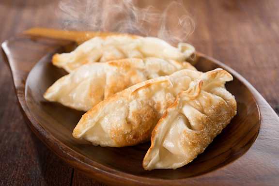 Three pastries on a brown plate with steam rising from them.