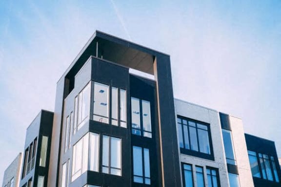 a tall building with many windows and a blue sky
