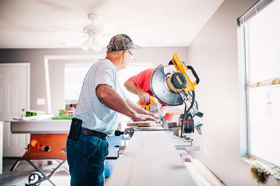 a man cutting wood with a saw