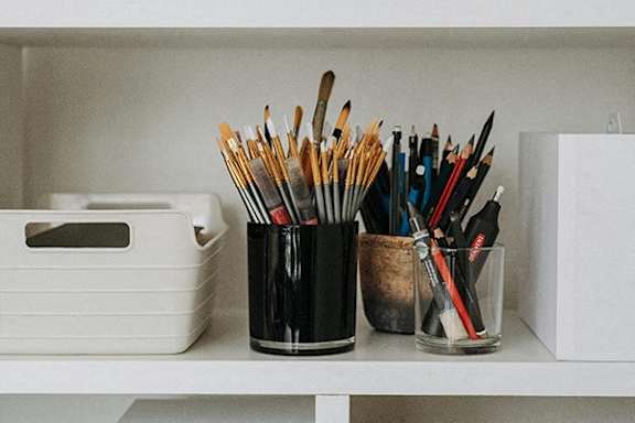 a desk with pens and pencils on it