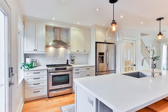 a kitchen with a large white island and stainless steel appliances