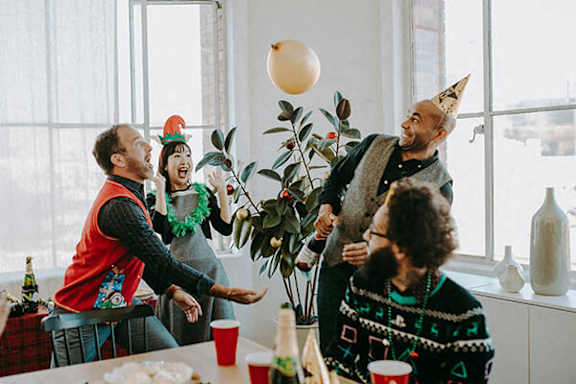 A group of people are celebrating with a balloon in the air.