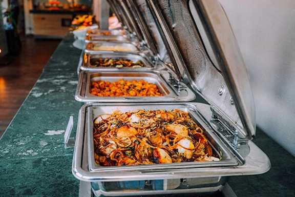 A buffet line with a variety of foods including seafood.