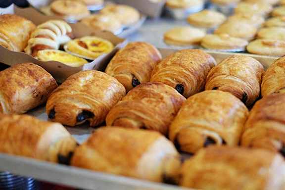 a variety of croissants on display at a bakery
