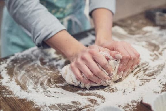 a person is kneading dough on a table
