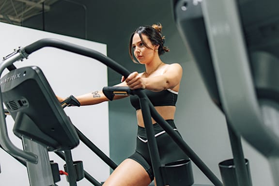 a woman workouts on a simulator in a gym