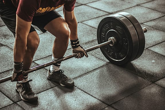 a man lifting a barbell in a gym