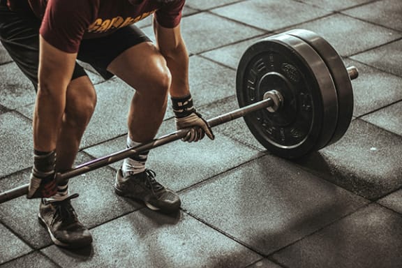 a person lifting a barbell in a fitness center