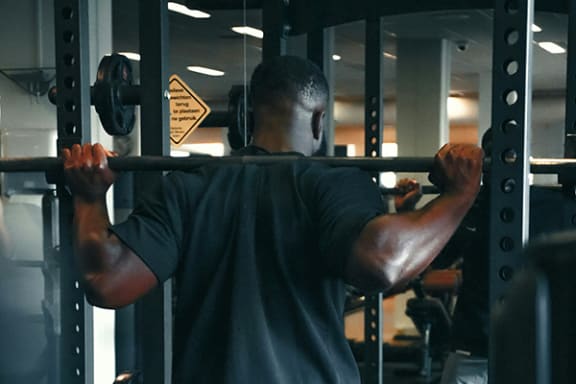 a man lifting a barbell in a gym