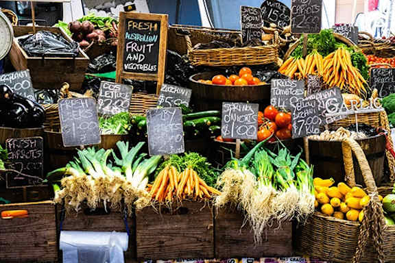 A fruit and vegetable stand with a sign that says "Fresh Necklion Fruit and Vegetables".
