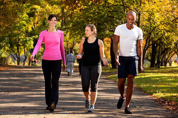 Three people are walking in a park.