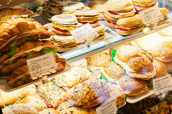 A display case filled with a variety of sandwiches and pastries.