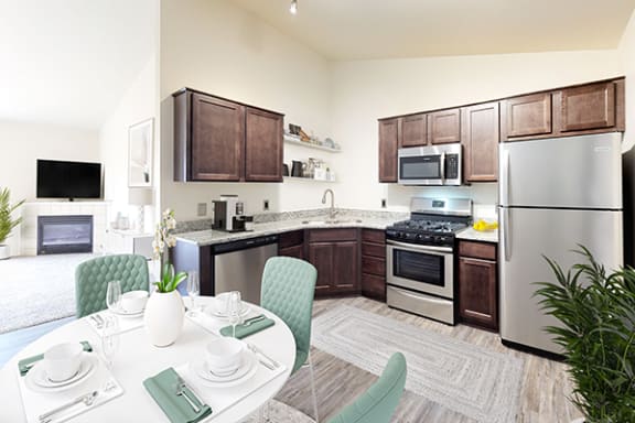 a kitchen with stainless steel appliances and a dining table