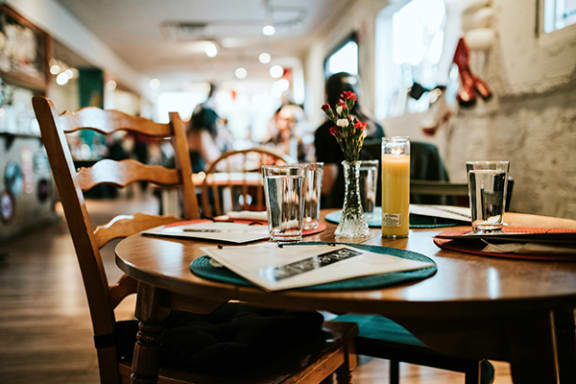 a table at a restaurant with a glass of beer on it