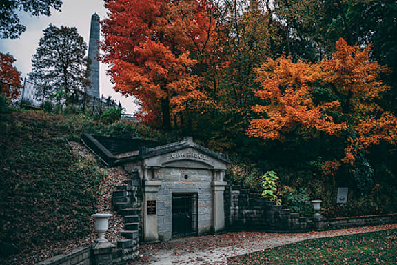 A small stone building with a gate in front of it.