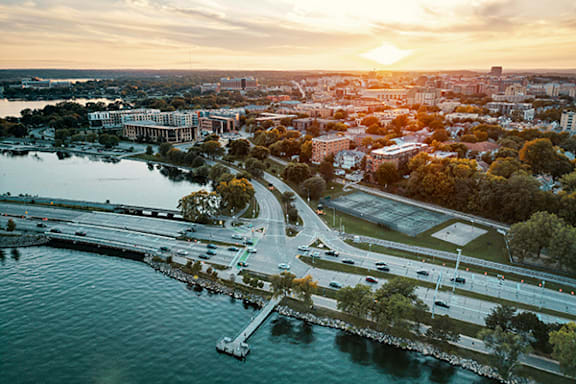an aerial view of a city with a river at sunset