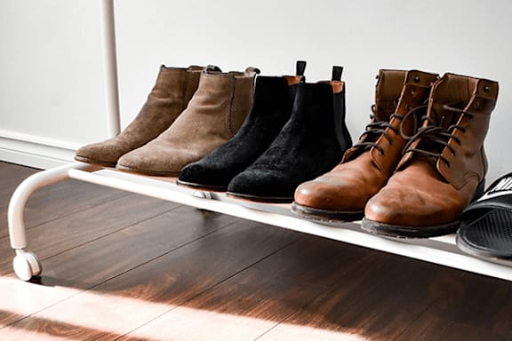 A row of boots are lined up on a shelf.