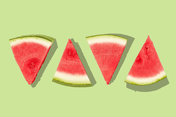 Three slices of watermelon on a green background.
