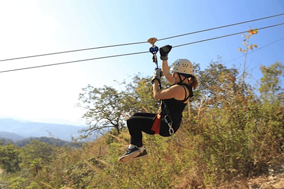 A person is ziplining through the trees.