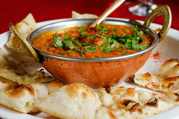 a bowl of soup with chips on a plate