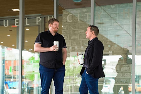 Two men are standing outside a building with the word "PULPIT" on it.