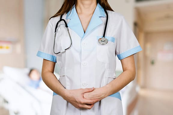 a nurse standing in a hospital with her hands on her hips