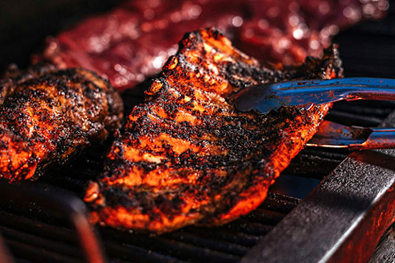 A close up of a steak being grilled on a barbecue.