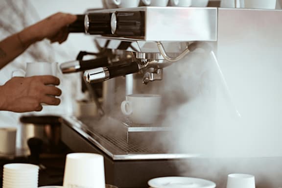A person is making coffee with a machine.