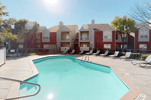 A swimming pool in front of apartment buildings.