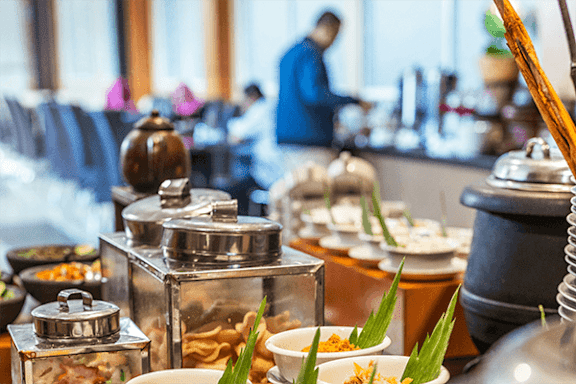 A buffet with a variety of foods including noodles and vegetables.
