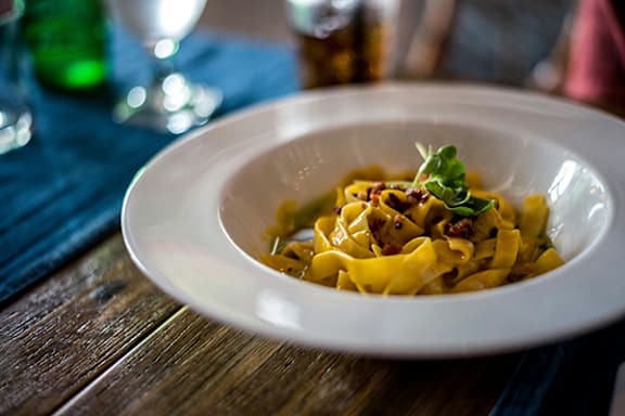 A white plate of food on a wooden table.