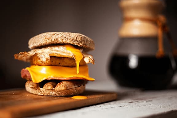 A sandwich with cheese and ham on a wooden board.